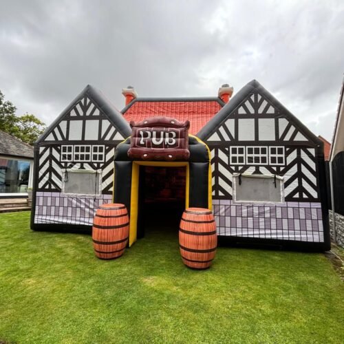The Tavern inflatable pub set up in a garden, with a clear front view and barrel props